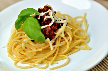 Detail of spaghetti bolognese with cheese and basil. Italian traditional pasta meal.