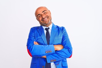 Middle age businessman wearing suit standing over isolated white background happy face smiling with crossed arms looking at the camera. Positive person.