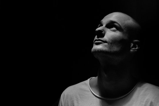 Confident Man Looking Up Against Black Background