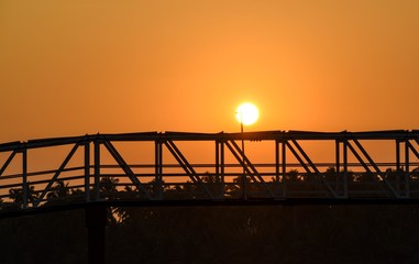 Silhouette of a bridge at dusk with beautiful sunset and red spread sky background