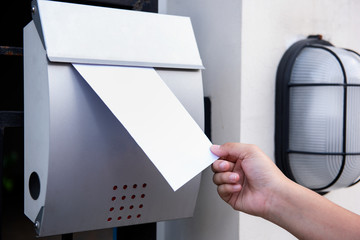  Hand inserting letters in mailbox