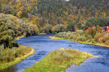 Poprad River in Autumn. View from bridge over Poprad between Piwniczna-Zdroj, Poland and Mnisek nad Popradom, Slovakia.