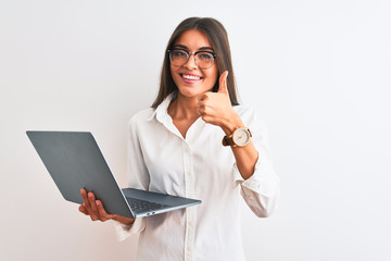 Beautiful businesswoman wearing glasses using laptop over isolated white background happy with big smile doing ok sign, thumb up with fingers, excellent sign