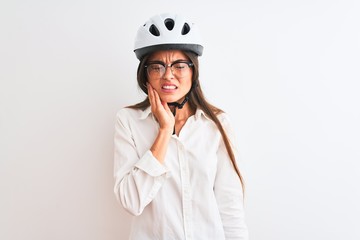 Beautiful businesswoman wearing glasses and bike helmet over isolated white background touching mouth with hand with painful expression because of toothache or dental illness on teeth. Dentist