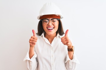 Young beautiful architect woman wearing helmet and glasses over isolated white background excited for success with arms raised and eyes closed celebrating victory smiling. Winner concept.