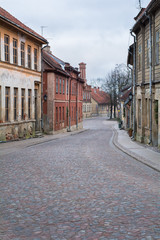 Old city street with old stone and wooden facades and stone paving road