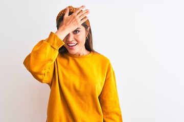 Young beautiful woman wearing yellow sweater and diadem over isolated white background surprised...