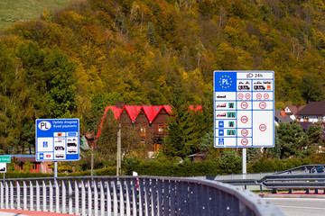 Road signs on country border display speed limits and tolls in Poland, near Piwniczna-Zdroj.