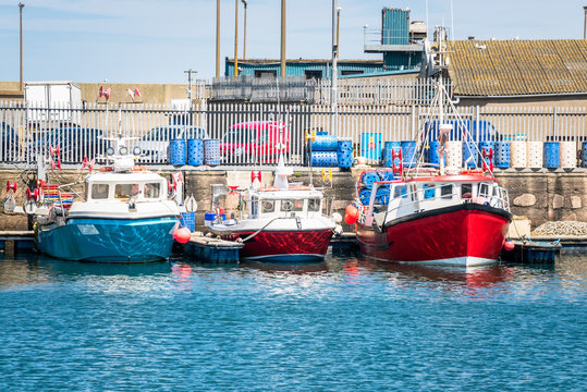Row of colourful fishing boats in a harbour on a sunny spring day