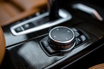 Media and navigation control buttons of a Modern car. Car interior details. Black leather interior of the luxury modern car. Modern car interior