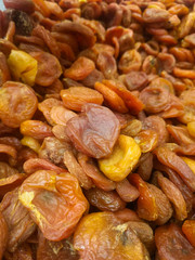 a mixture of large and small dried apricots on a supermarket counter