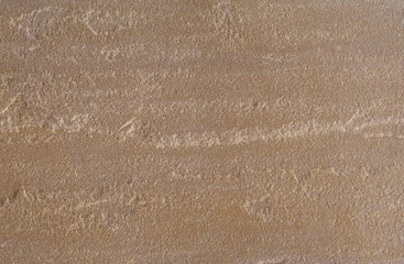 Oberfläche einer feinstrukturierten Platte aus braunen Sandstein