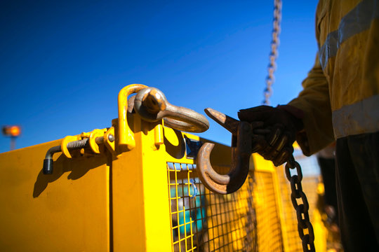 Close Up Industrial Rigger High Risk Worker Hand Wearing Safety Heavy Duty Glove And Clipping A Crane Hook Into Yellow Crane Lifting Gate Prior Lifting In Construction Site Perth City, Australia 