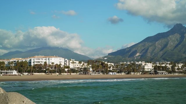 Gimbal shot of Marbella La Concha mountain left to right and the seaside at daylight. Sea coast in the marina of Luxury yacht of Puerto Banus located, Spain