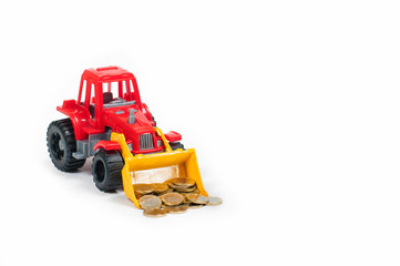 coins of twenty fifty cents and one Euro in the bucket of a toy red bulldozer on a white background side view from the front