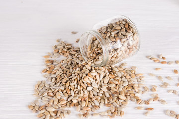 sunflower seeds in a jar  on white wooden background. vegetarian food, eco food concepts