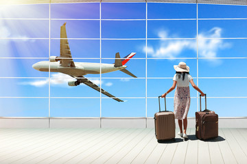 Young woman passenger with suitcases in airport terminal, travel concept