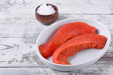 Fresh red caviar in the egg sack. Process of preparing for salting