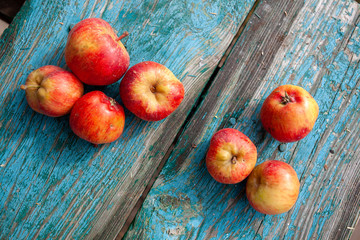 Red apples on a blue old painted board.