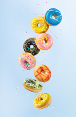 Various colorful doughnuts in motion on blue background