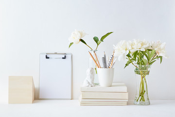 Home interior with decor elements. Mockup clipboard, white peonies in a vase, interior decoration