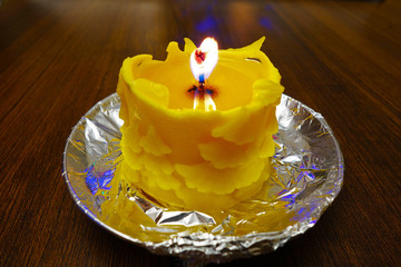 Burning Christmas candle cast from beeswax