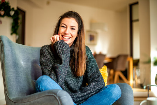 Happy Woman Relaxing At Home In The Armchair