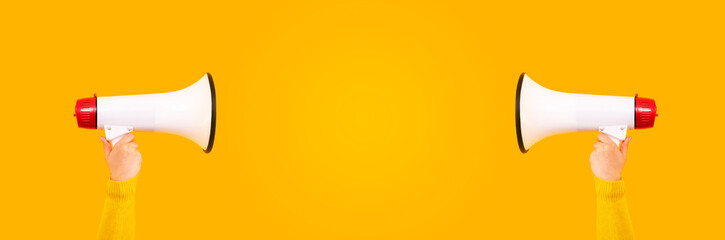 Fototapeta premium megaphones in hands on a yellow background, panoramic mock-up image with space for text, attention concept announcement