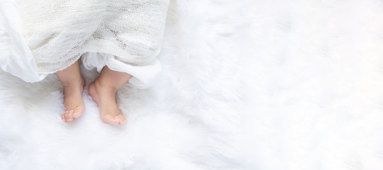 Cute newborn baby girl in white blanket on nursery bed. Adorable new born child, little boy...