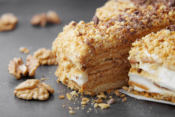 baked pie with cream and nut crumbs, a slice of delicious pastries on a dark background