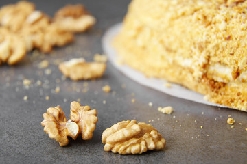 baked pie with cream and nut crumbs, a slice of delicious pastries on a dark background