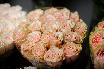 Beautiful bouquet of tender peach color roses in the transparent wrapping paper