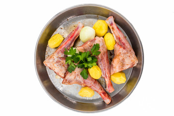 Lamb shank kebab on tray and potato onions around