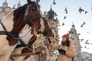 Young woman and horses at Main Square in Krakow, Poland