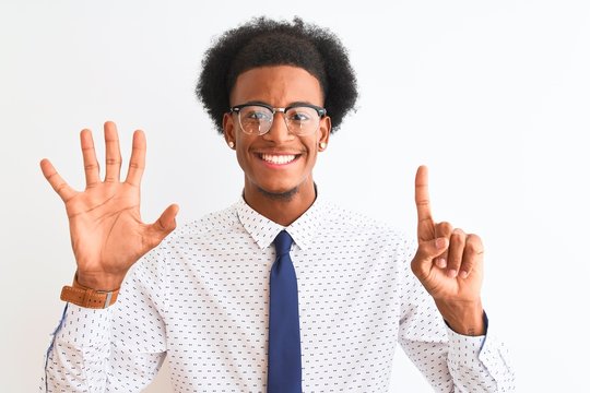 Young african american businessman wearing tie and glasses over isolated white background showing and pointing up with fingers number six while smiling confident and happy.