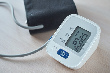 Digital blood pressure monitor on the table, closeup. Helathcare and medical concept