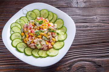 Fresh salad of vegetables and meat on wooden rustic background