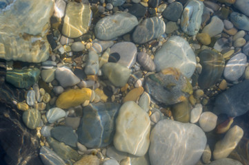 pebble stones on the sea beach, the rolling waves of the sea with foam