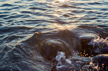 pebble stones on the sea beach, the rolling waves of the sea with foam