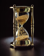 brass hourglass filled with gold 