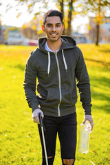 Confident young man cleaning park on sunny day