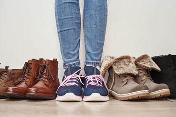 Woman chooses comfortable brown leather shoes among bunch of the different pairs