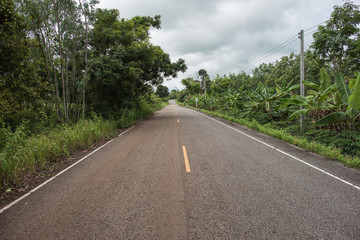rural road with cloudy sky in northeastern Thailand in the udon thani province.