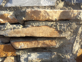 Gray and orange stone wall background texture with sun light reflection