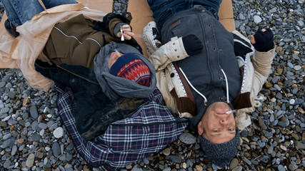 homeless couple, man and woman, staying overnight by the sea