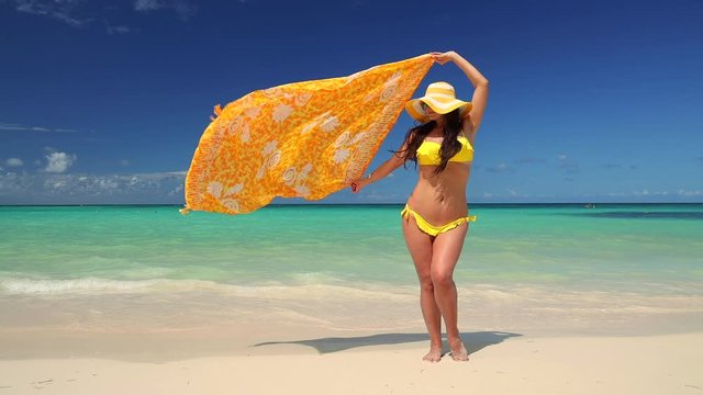 Carefree young woman relaxing on exotic beach. Caribbean tropical vacation. Dominican Republic.