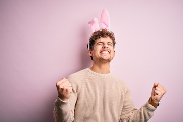 Young handsome blond man wearing easter rabbit ears over isolated pink background very happy and...