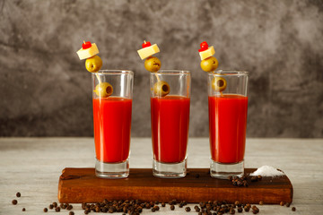 Bloody Mary Cocktail Bar with a variety of side dishes. Bloody Mary tomato juice with vodka olives lemon and pepper on a gray background.