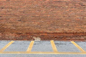 red brick building wall alley yellow loading zone parking space asphalt driveway