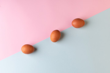 Three easter eggs on a two-color background. Flat lay minimalism.